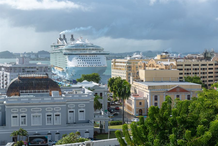 Giant cruise ship towering over the historic buildings of Old San Juan, Puerto Rico