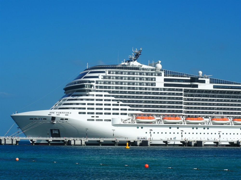 MSC Virtuosa cruise ship docked in a sunny harbor